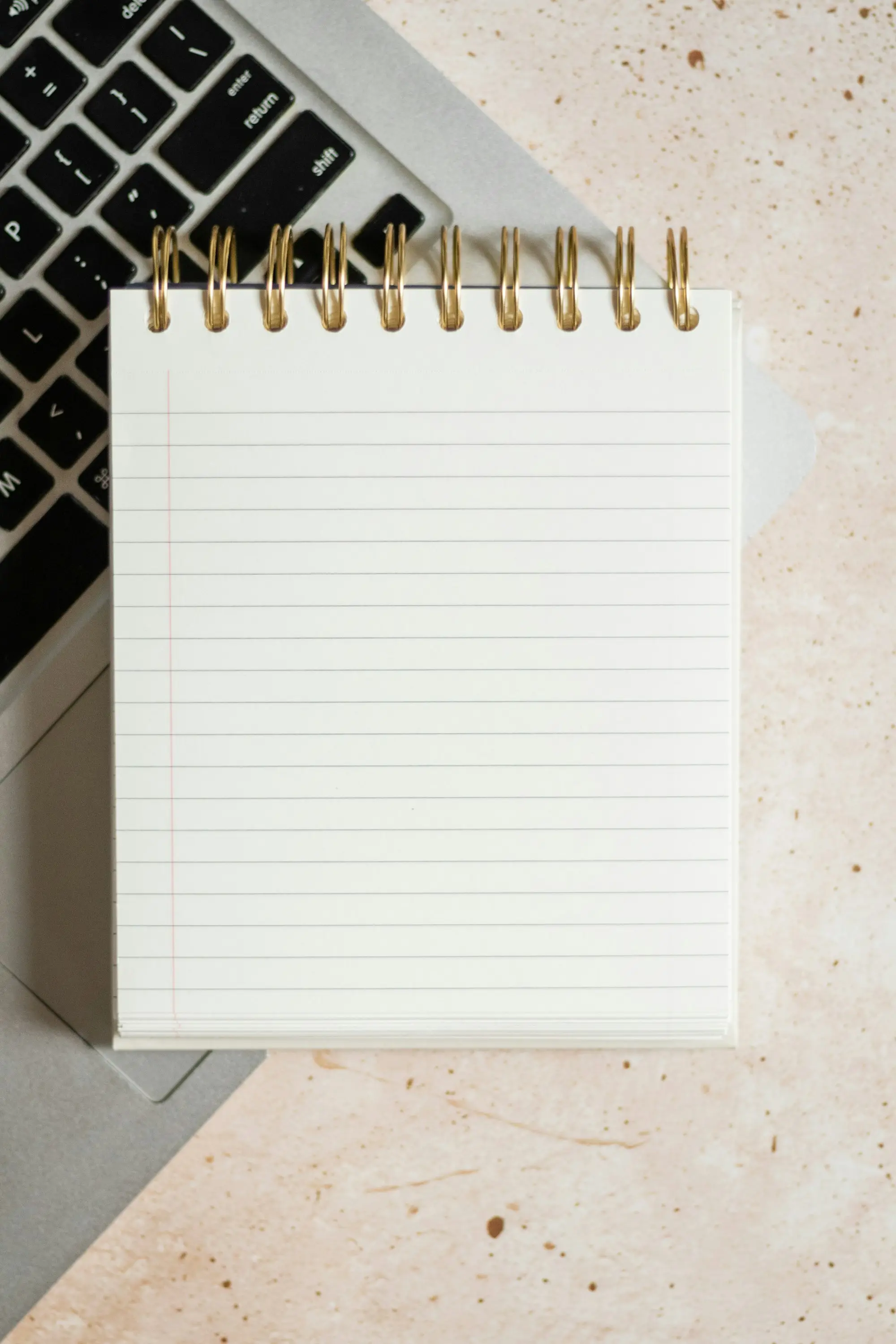 A blank notepad resting on a laptop